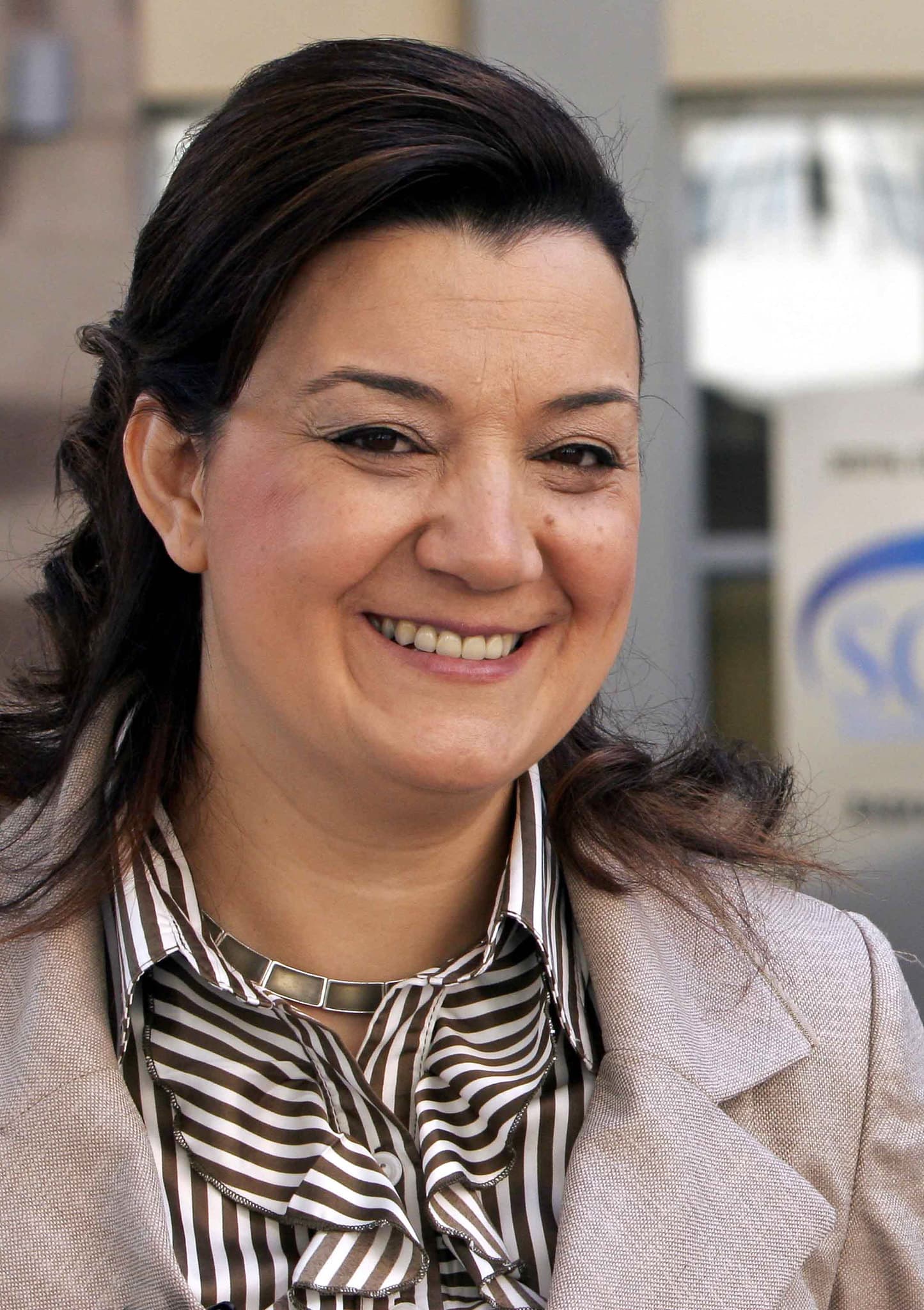 A smiling woman wearing a suit.
